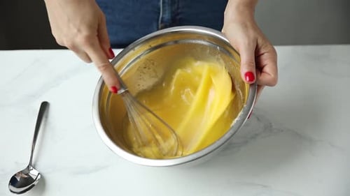A Woman In A Home Kitchen Preparing A Cupcake