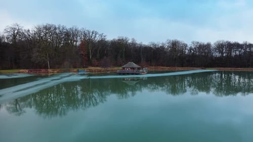 Aerial: wooden house on Verchat pond and Cabanes des Grands Reflets during the day in Joncherey