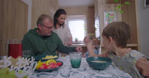 Family Enjoys Meal Together at Kitchen Table