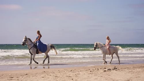 Young Girls Horseback Riding At The Beach