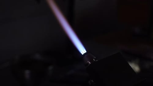 Flame demonstration using a torch for metalworking in a workshop at night