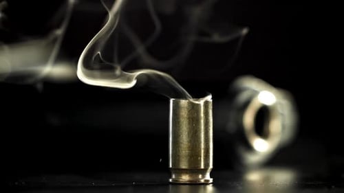 Smoking Bullet Casing on Black Background, Firearm Crime