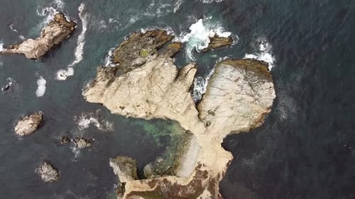 Aerial View of Rocky Coastline Meeting the Ocean