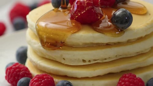 Pancake Stack with Berries and Dripping Maple Syrup