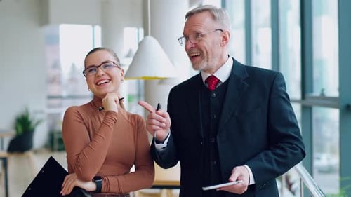 Smiling colleagues talking in the office.