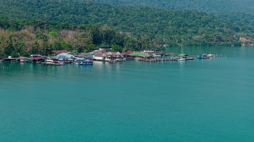 Aerial View of the Floating Wooden Houses of a Coastal Village on the Lush Island
