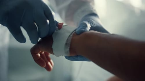 Unrecognized african american man's hand receiving iv treatment in hospital intensive care unit
