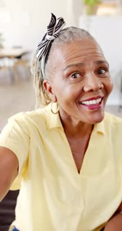 Vidéo verticale : Une femme afro-américaine âgée au sourire éclatant lève les yeux