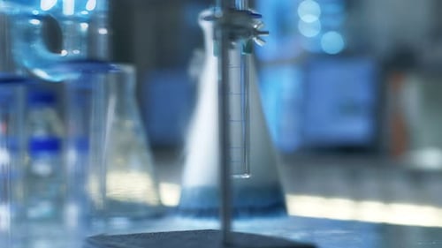Laboratory Equipment Bubbling with Blue Fluid and White Smoke