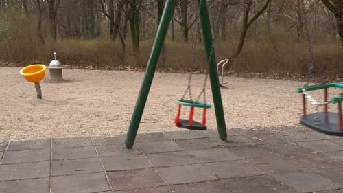 Empty Playground with Swinging Swings in the Daytime