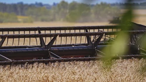 Close-up modern combine machine moving in dust.