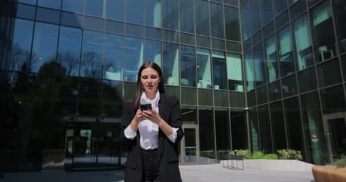 Excited Businesswoman Celebrating Success Outside Office Building