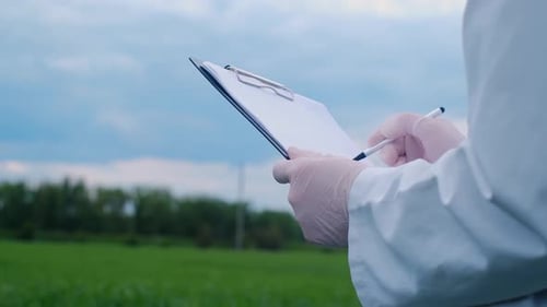 Botanist scientist analyzing plant crop making notes in a journal. Woman gardener biologist testing