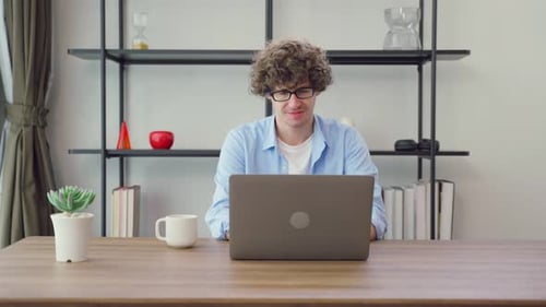 Man Working on Laptop at Home Office Desk