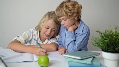 Irmãos do Ensino Fundamental Primário, Meninos e Meninas Estudando na Mesa, Escrevendo em Livro e Tablet