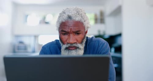 Mature Man Working on Laptop at Home