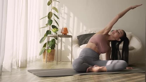Young Woman Doing Yoga and Stretching Indoors