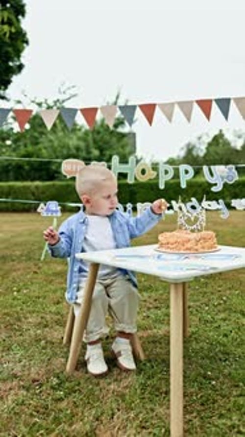 Children's photo zone for a 2 year old boy with a sweet cake. Child's birthday outdoors