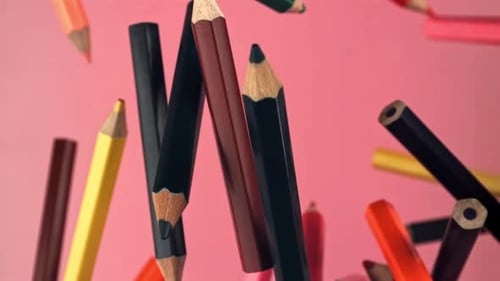 Multicolored Pencils Flying on a Pink Background Filmed on a Highspeed Camera at 1000 Fps