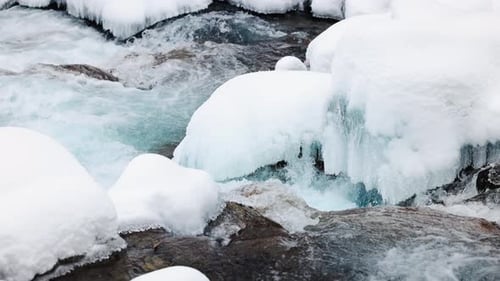 River Stream at Winter Snow Forest in the Mountains