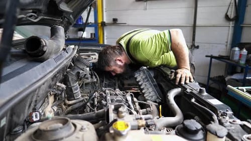 Professional Repairman Inspecting Car Engine at Service Adult Auto Mechanic Working Under Hood of
