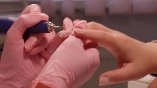 Nail Salon: Manicurist Shaping Nails with Electric File