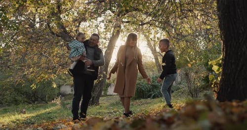 Family with Two Children Have Fun in Autumn Park