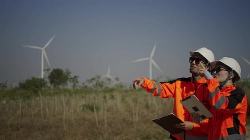 Engineers work at windmill farm.