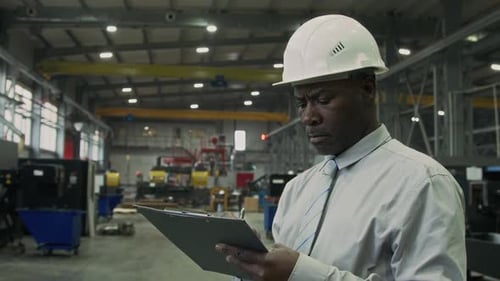 Serious Supervisor Monitoring Production Process and Making Notes