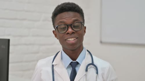 Smiling Doctor Talking and Gesturing to Camera