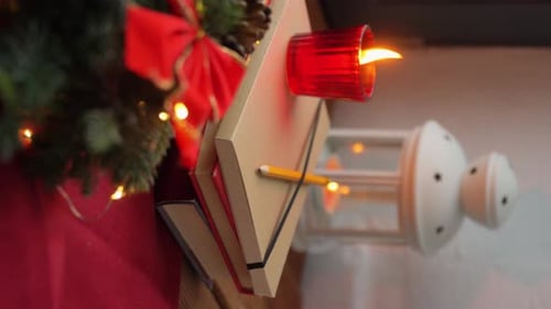Holiday candle and seasonal decorations on table