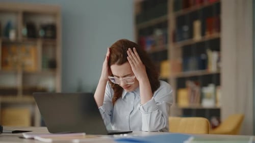 Stressed woman experiencing headache at work