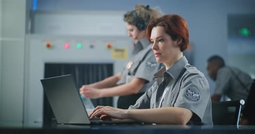Airport Security Checkpoint Female Security Officer Working on Laptop Computer