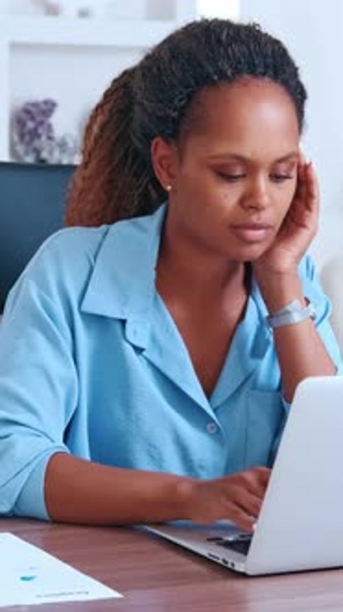 Jeune femme afro-américaine axée sur le travail dans un bureau lumineux et moderne