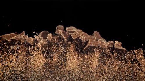 Falling Chocolate Chunks and Powder on Black Background
