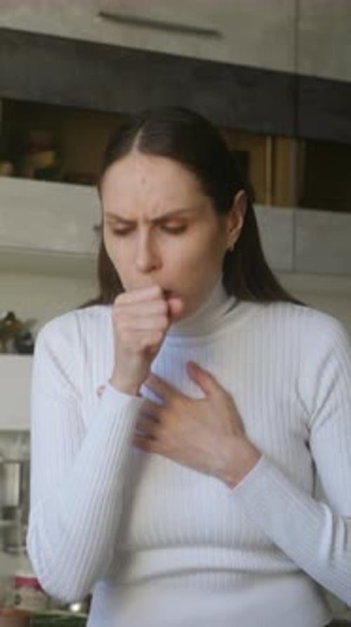 Woman Coughing at Home, Covering Mouth With Fist