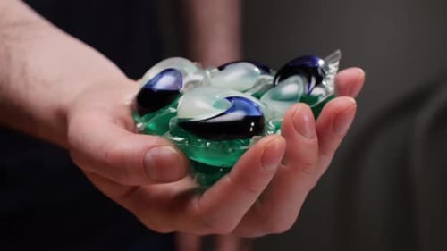 Hand Holding Laundry Detergent Pods Close Up