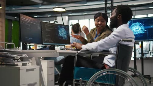 Fröhlicher Techniker mit Behinderung und Mitarbeiter, die beim Programmieren von KI chatten