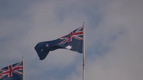 Australian Flags Waving in the Wind Under Blue Sky