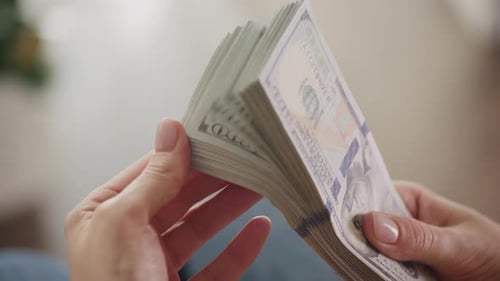 Woman Holding Stack of Hundred Dollar Bills