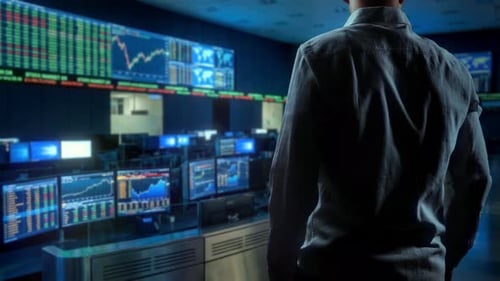 Focused Financial Trader Carefully Watches Several Monitors Showing Market Activity In Subdued