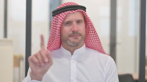Man in Traditional Dress Says No with Finger