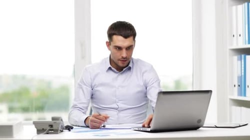 Business Man Working at Desk Talking on Phone