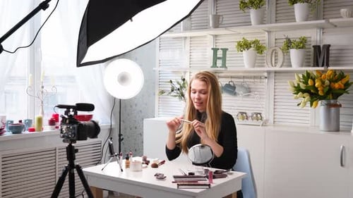 Mujer bloguera de belleza filmando un tutorial diario de rutina de maquillaje ante la cámara, la influencer Blonde Lady Live