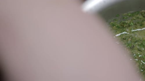 Preparation of a delicious herb butter. The cook mixes the ingredients. Close-up.