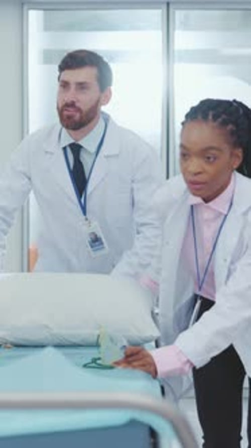 In the Hospital Multiethnic Male and Female Doctors Moving Stretcher Bed Through Corridor on