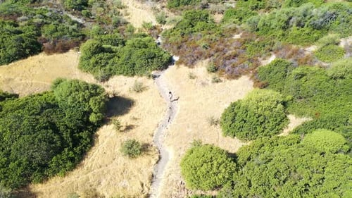 Aerial view of a person walking a countryside trail in Sardinia, Italy.