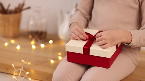 Woman Untying Present at Home