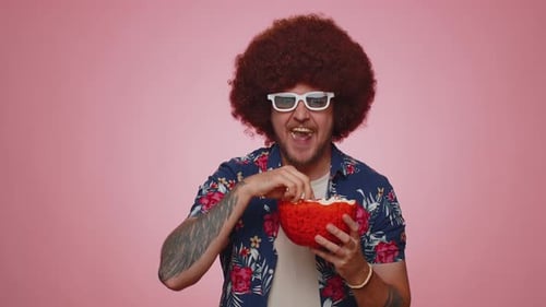 Man with Afro Enjoys Popcorn and Cheers