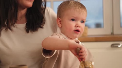 Mother and Child in Kitchen Eats Pureed Food